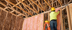 Contractor installing fiberglass insulation